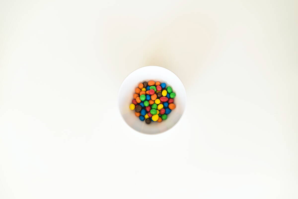 daughters-of-time_bulletjournal_timemanagement Eine weisse Schale auf weissem Grund mit vielen bunten Smarties darin.