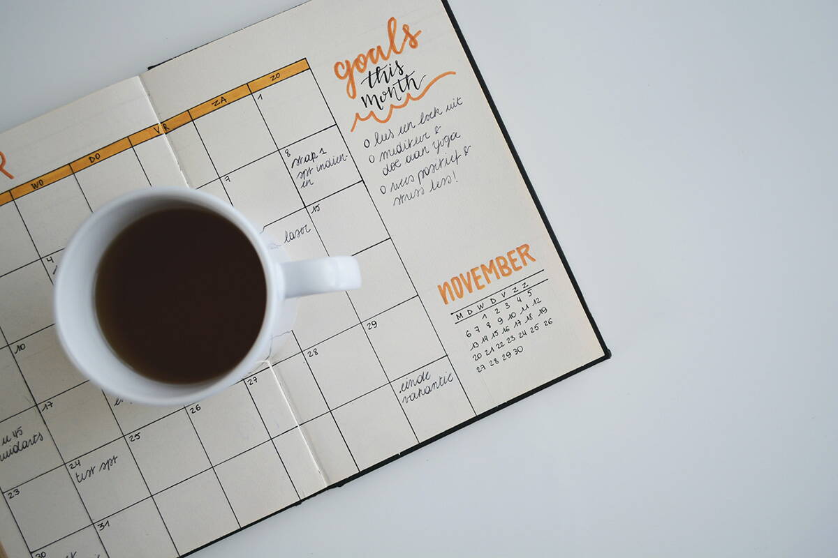 Eine Teetasse steht steht auf einem Notizbuch. Es steht "Goals this month" und "November". 