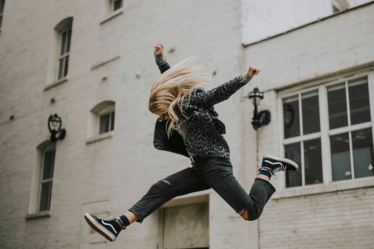 Eine Frau springt kraftvoll in die Luft. 