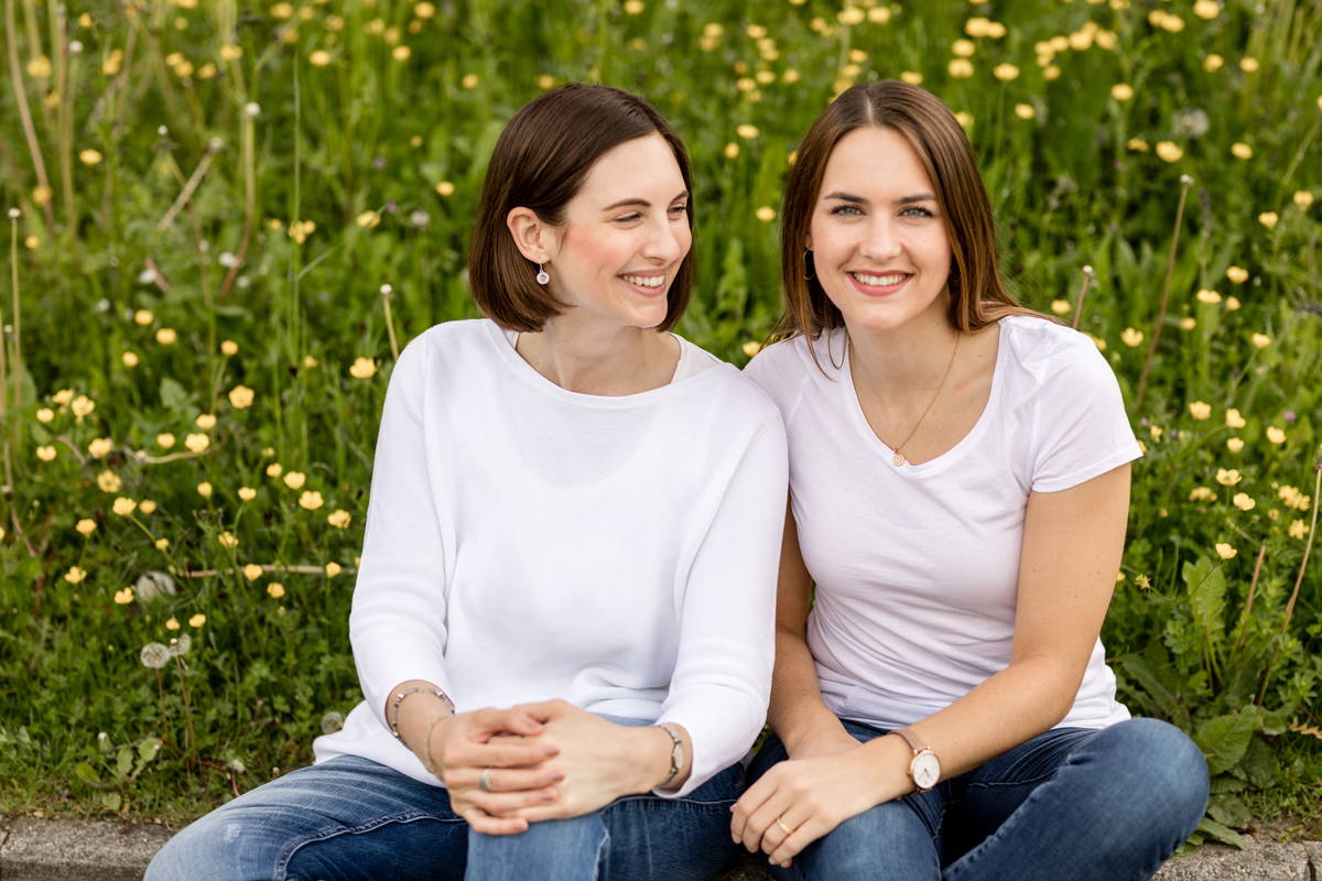 Chantal und Fabienne sitzen im Feld.