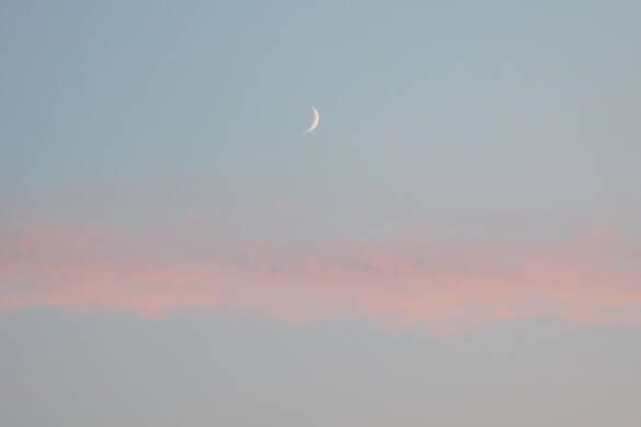 trust_the_process_moon_breathwork.jpg Eine dünne Mondsichel leuchtet am blaugrauen Himmel, der von einer rosaroten Wolke untermalt wird.
